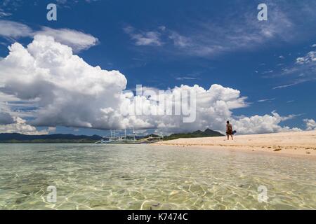 Philippines, Palawan, Taytay Bay, Isla Blanca, woman walking on the sand beach Stock Photo