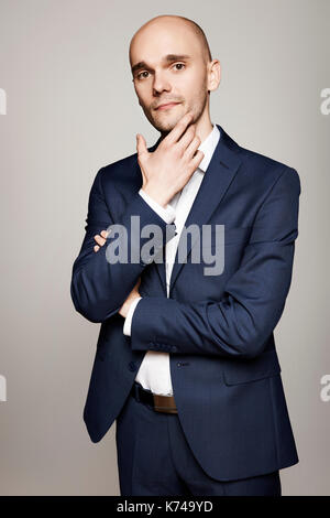 Portrait of young pensive man touching his chin. Stock Photo