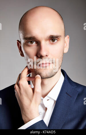 Close up of pensive young man stroking his chin. Stock Photo