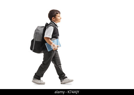 Full length profile shot of a schoolboy with a backpack walking isolated on white background Stock Photo