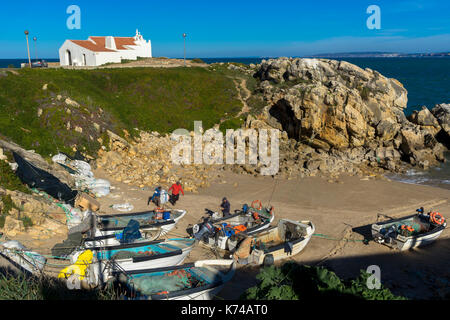 Local fishing boats pulled up on the beach in a small cove in Baleal Portugal Stock Photo