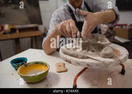 Mid-section of senior man molding clay in drawing class Stock Photo