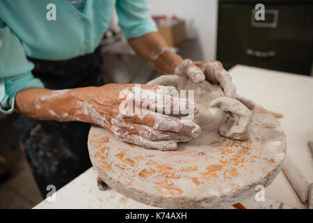 Mid section of man molding clay in class Stock Photo