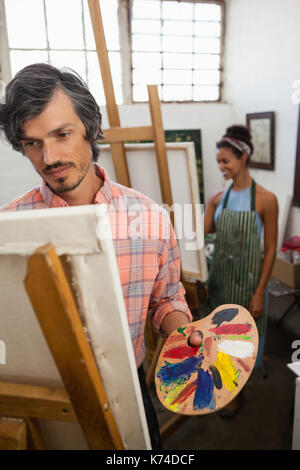 Man and woman painting on canvas in drawing class Stock Photo