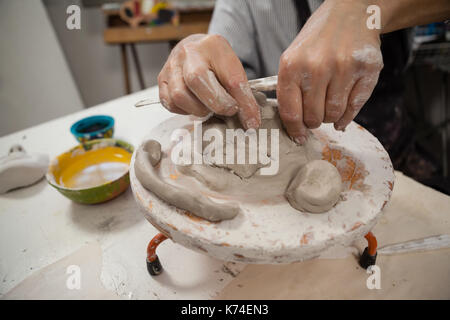 Mid section of man molding clay in class Stock Photo