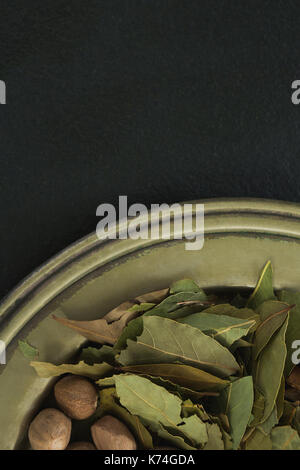 Close-up of nutmeg and bay leaf in tray Stock Photo