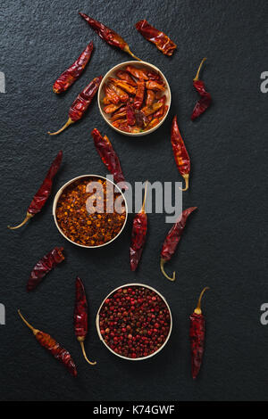 Overhead of dried red chili pepper and crushed red pepper in bowl Stock Photo