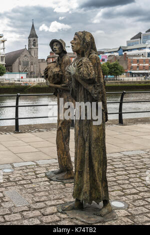 Dublin, Ireland - August 7, 2017: Great Irish Famine bronze statue set on Custom House Quay along Liffey River in Docklands.. Two figures, male and fe Stock Photo