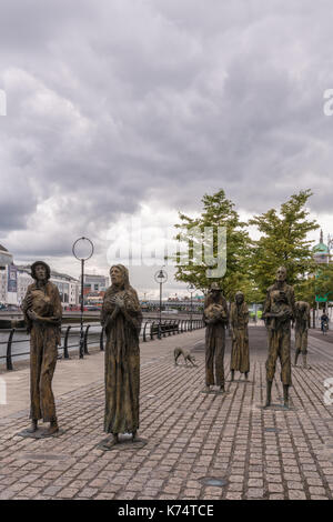 Dublin, Ireland - August 7, 2017: Great Irish Famine bronze statue set on Custom House Quay along Liffey River in Docklands. All six figures, male and Stock Photo