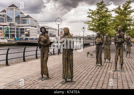 Dublin, Ireland - August 7, 2017: Great Irish Famine bronze statue set on Custom House Quay along Liffey River in Docklands. All six figures, male and Stock Photo