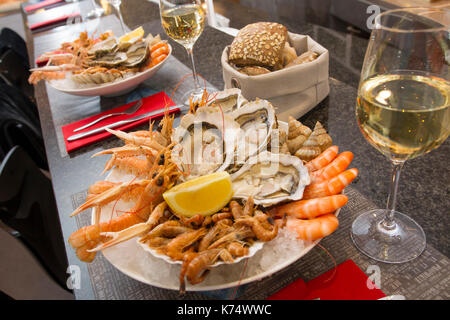 Seafood platter : oysters, jumbo shrimps, prawns, sand shrimp, whelks and glass of white wine Stock Photo