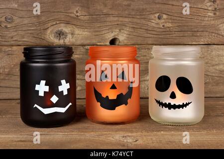 Mason jar Halloween candle holders against an old wood background Stock Photo
