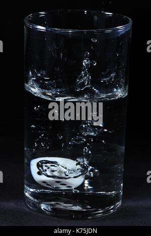 Detail von Spielwürfel mit schwarzen hintergrund im Wasserglas Detail of dice with black background in a teacup Stock Photo