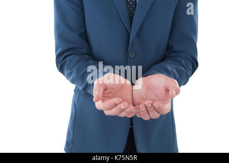 Mid section of businessman with hands cupped advertising invisible product while standing against white backgorund Stock Photo