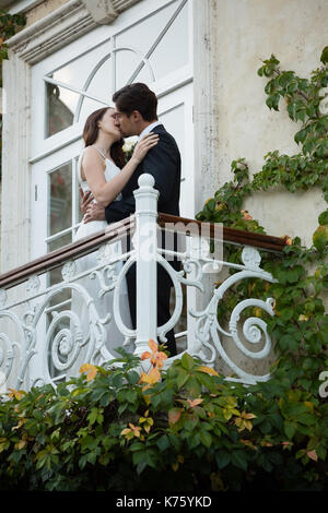 Low angle view of romantic couple kissing while standing in balcony Stock Photo