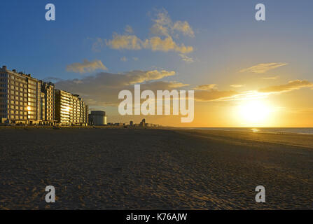 Apartment buildings at sunset along the waterfront and beach of Ostend city in Belgium by the North Sea. Stock Photo