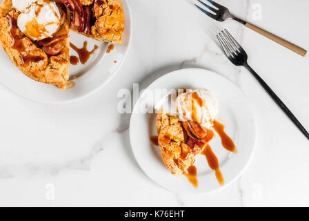 Traditional autumn baking, recipes for thanksgiving, Homemade wholegrain apple galette pie with organic apples and cinnamon, white marble table, copy  Stock Photo