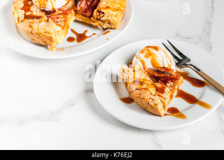 Traditional autumn baking, recipes for thanksgiving, Homemade wholegrain apple galette pie with organic apples and cinnamon, white marble table, copy  Stock Photo