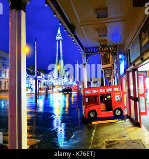 Blackpool tower and the illuminations on a wet night viewed from North Pier amusement arcade Stock Photo