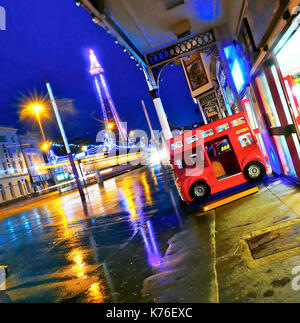 Blackpool tower and the illuminations on a wet night viewed from North Pier amusement arcade Stock Photo