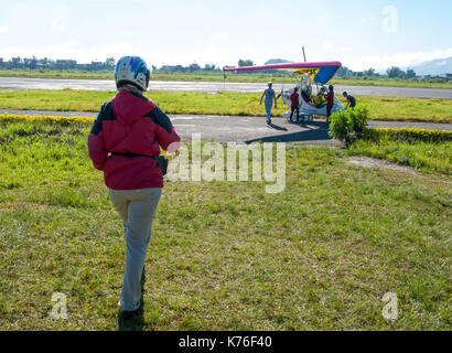 Foreign tourist prepares for flight on a hang glider (deltaplan).  Pokhara, Nepal, Himalayas Stock Photo