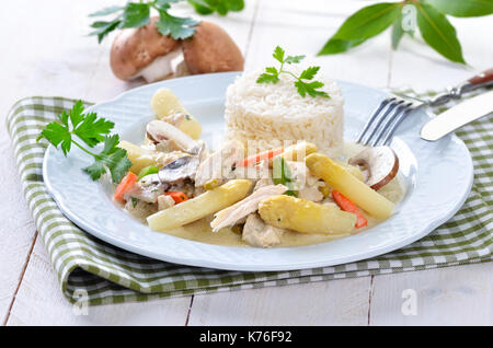 Chicken fricassee with fresh white asparagus, rice and mushrooms Stock Photo