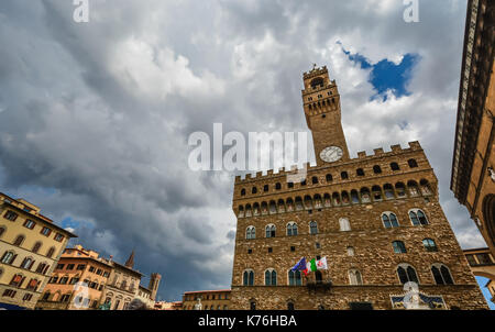 The clock and tower of the Palazzo Vecchio in the Tuscan region of Florence Italy as a storm approaches Stock Photo