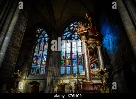 A colorful stained glass window inside St Vitus Cathedral in Prague Castle Complex Stock Photo