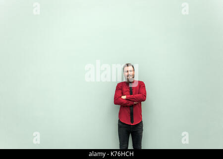 Young adult businessman crossed hands and looking at camera. Studio shot on gray background Stock Photo