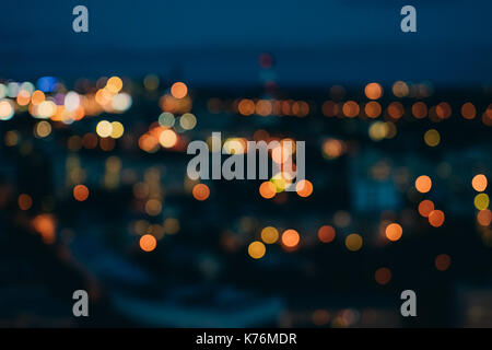 Blurred city lights against dark evening sky. Abstract background with urban bokeh Stock Photo