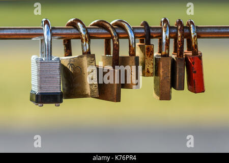 Padlock of love hanging on the wire, rusty. Stock Photo