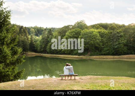 Senior couple on a walk at the lake hugging. Stock Photo