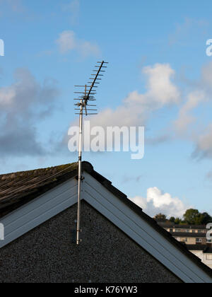 TV aerial on gable end against a blue sky with some clouds Stock Photo