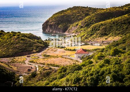 United Kingdom, Montserrat, English-speaking Caribbean, Brades, the new capital to the north of the island is still under construction, here view on the cricket ground and the maritime pontoon of Little Bay Stock Photo