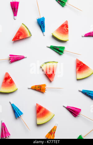 Cocktail umbrella and watermelon summertime background Stock Photo