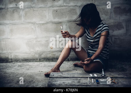 Drug addict young woman with syringe in action, Drug abuse concept. Stock Photo