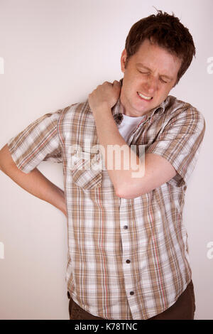 A sore shoulder joint muscle in a white man on a white background back ...