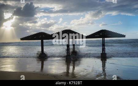 Hurricane and tropical storm. Dunes on a beach.Water level reaches beach umbrellas Stock Photo