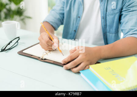 Student doing homework and preparing exam at home. Stock Photo