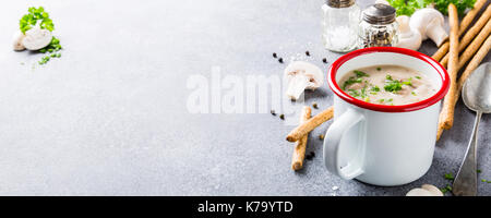 Delicious homemade mushrooms champignons soup with parsley in enamel mug. Healthy food concept with copy space. Stock Photo