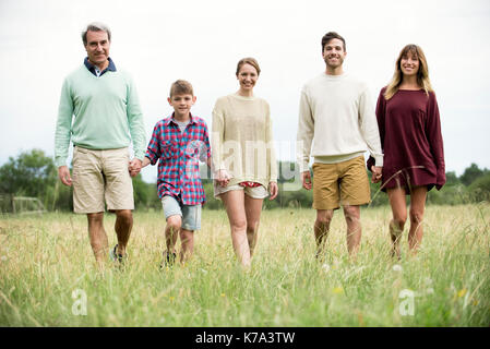 Family walking together through meadow Stock Photo