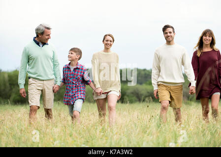 Family walking together through field of tall grass Stock Photo