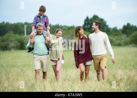 Family walking through field together Stock Photo