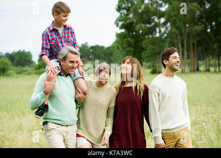 Family walking together through field Stock Photo