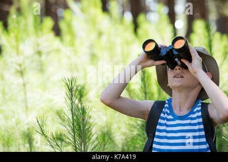 Boy looking through binoculars Stock Photo