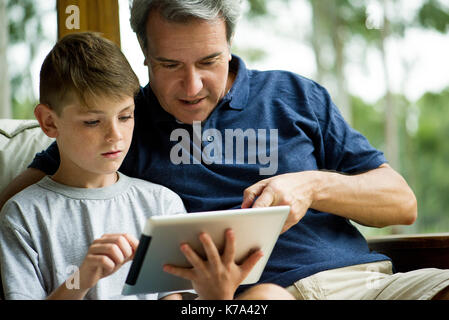 Man with child using digital tablet Stock Photo