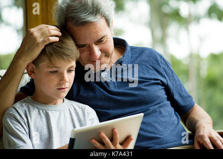 Man with child using digital tablet Stock Photo