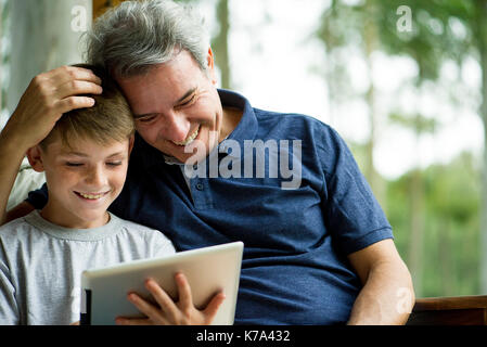 Man with child using digital tablet Stock Photo