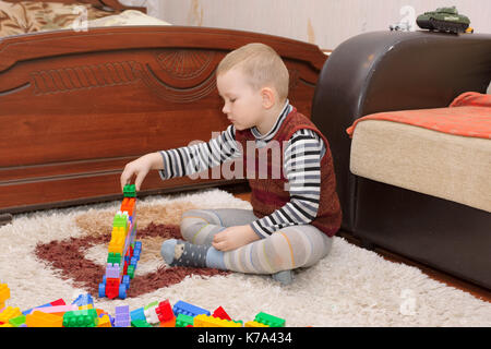 boy playing with blocks and train on the floor Stock Photo