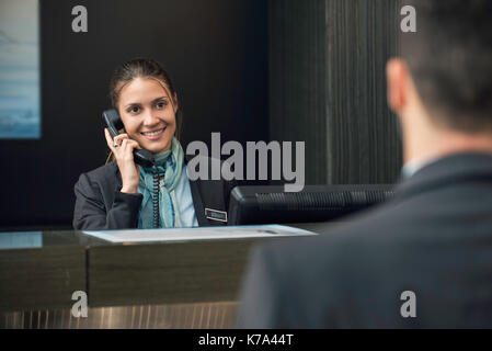 Hotel receptionist talking on phone Stock Photo